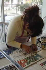 Artists working on the giving is universal mosaic in the Piece by Piece LA studio.